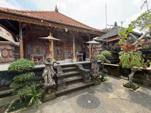 a house with statues in front of a building at Eka's Homestay in Ubud
