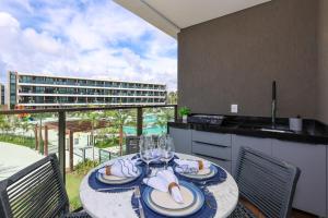 a dining room with a table and a balcony at Beach Class Verano in Porto De Galinhas