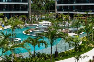 an image of a resort pool with palm trees at Beach Class Verano in Porto De Galinhas