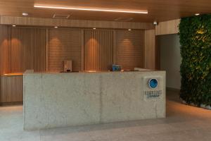 a lobby with a reception desk in a building at Beach Class Verano in Porto De Galinhas +53 photos