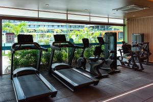 a gym with treadmills and ellipticals in a building at Beach Class Verano in Porto De Galinhas
