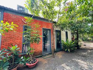 a red brick house with plants in front of it at Homestay Phố biển cam bình in Lagi