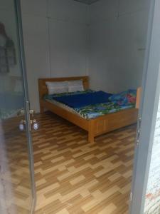 a bedroom with a bed and a wooden floor at Homestay Phố biển cam bình in Lagi