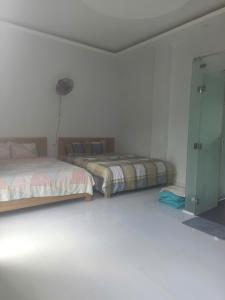 a bedroom with two beds and a glass door at Homestay Phố biển cam bình in Lagi