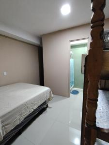 a bedroom with a bed and a door to a bathroom at Beto's house in Santa Ana