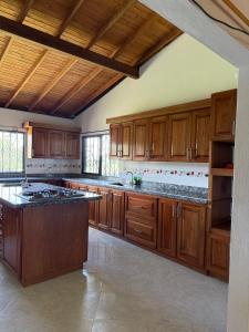 a large kitchen with wooden cabinets and a large island at Finca María Bonita in Horizonte