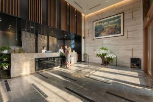 a lobby of a hotel with people standing at a counter at Cat Ba Paradise Hotel - Sky Bar & Massage in Cat Ba +164 photos