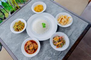 a table with bowls of food and rice on it at Kings Ridge Kandy in Kandy