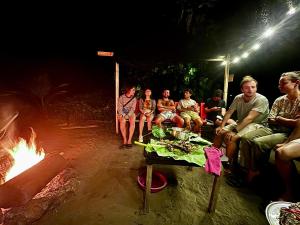 a group of people sitting around a fire at night at La Roca House in El Valle