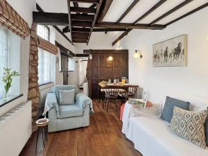 a living room with a couch and a table at Stables Cottage Ellicombe in Minehead +13 photos