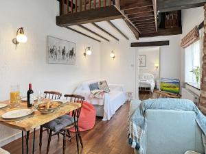 a living room with a table and a couch at Stables Cottage Ellicombe in Minehead