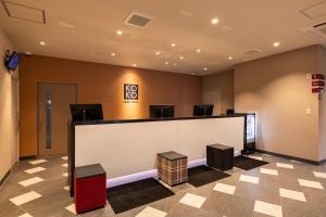 a waiting room with a reception counter and chairs at KOKO HOTEL Hakata Station in Fukuoka