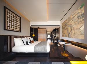 a bedroom with a bed and a large painting on the wall at SEYA Design Hotel - Chengdu Taikoo Li - Managed by SEYA GROUP in Chengdu
