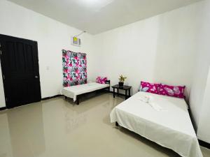 a white room with two beds and a window at ChicPoint Guesthouse in Sampong