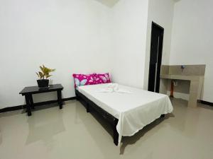 a bedroom with a bed and a table with a plant at ChicPoint Guesthouse in Sampong