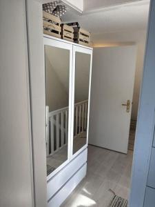 a room with a large cabinet with glass doors at Golfhues-Simone-Ferienwohnung-Suedbalkon in Wulfen auf Fehmarn