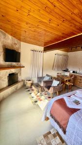 a bedroom with a bed and a living room at Chalé Vista Verde in Monte Verde