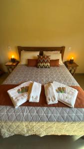a large bed with four pillows on it at Chalé Vista Verde in Monte Verde