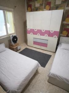 a bedroom with two beds and a tv in it at Cozy Mini Villa with a backyard in 6th Of October
