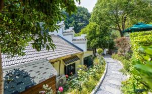 a house with a pathway next to a building at Taofanting Riverside Hotel in Yichang