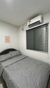 a bedroom with a bed and a air conditioner on a window at Solara Villa, Gensan in General Santos