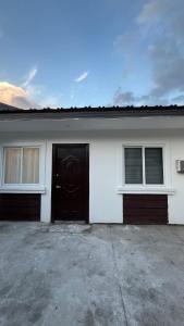 a white house with a black door and two windows at Solara Villa, Gensan in General Santos