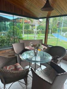 a patio with a glass table and chairs at Privê Refúgio Gravatá in Gravatá
