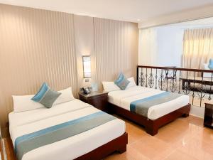 a hotel room with two beds and a balcony at Boracay Summer Palace Hotel in Boracay