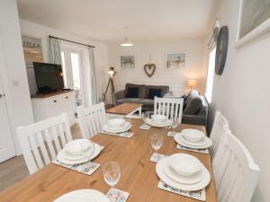 a dining room with a table and chairs and a living room at Coastal Cottage in Reighton