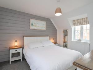 a bedroom with a large white bed and two tables at Coastal Cottage in Reighton