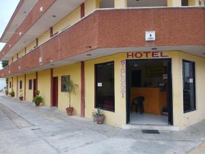 a hotel with a yellow and red building at Hotel Siglo XXI in Dzidzantún