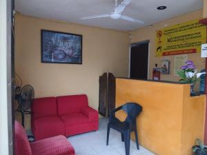 a waiting room with a red couch and a counter at Hotel Siglo XXI in Dzidzantún