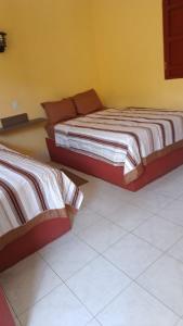 two beds sitting next to each other in a room at Hotel Siglo XXI in Dzidzantún