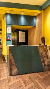 a lobby with a counter and yellow walls at C2 Pods in Varanasi
