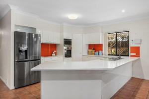 a kitchen with white cabinets and a stainless steel refrigerator at Spacious 4BR Waterfront Stay Pool Table AC in Newport