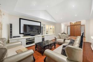 a living room with couches and a large tv at Spacious 4BR Waterfront Stay Pool Table AC in Newport