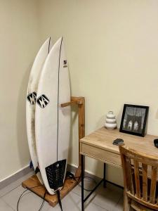 two surfboards leaning against a wall next to a table at Islas Boho Tiny Home - Main strip El Tunco in El Sunzal