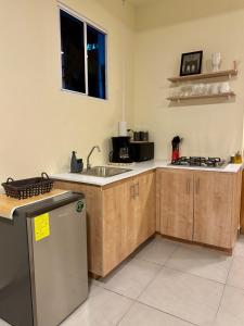 a kitchen with wooden cabinets and a sink at Islas Boho Tiny Home - Main strip El Tunco in El Sunzal +12 photos