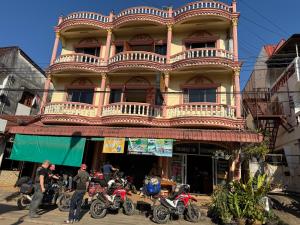 a group of motorcycles parked in front of a building at Thaveesinh Hotel in Ban Houayxay