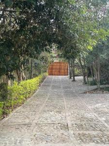 a brick road with a fence in the distance at Ecohotel Naranjos in Jenesano