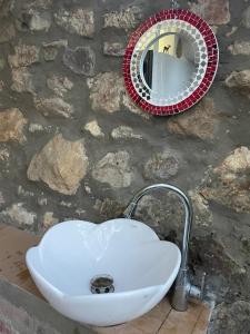 a sink and a mirror on a stone wall at Ecohotel Naranjos in Jenesano