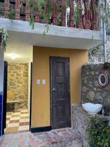 a house with a door and a sink on the side at Ecohotel Naranjos in Jenesano