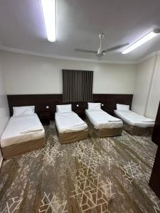 a room with three beds and a ceiling at فندق جاردنز أوف كومفورت in Az Zahrāʼ