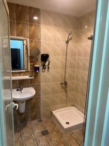 a bathroom with a shower and a sink and a toilet at فندق جاردنز أوف كومفورت in Az Zahrāʼ