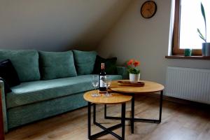 a living room with a green couch and two tables at Sosnówka in Kolonowskie +6 photos