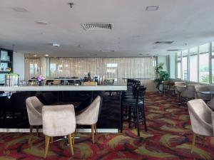 a lobby with a bar and a lot of chairs at Pan Borneo Hotel Kota Kinabalu in Kota Kinabalu