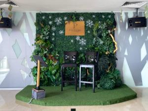 a green wall with two chairs in front of it at Pan Borneo Hotel Kota Kinabalu in Kota Kinabalu