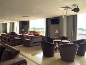 a waiting room with couches and tables and chairs at Pan Borneo Hotel Kota Kinabalu in Kota Kinabalu