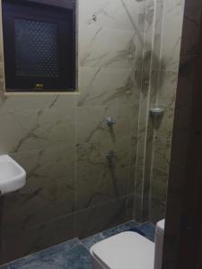 a bathroom with a shower with a toilet and a television at Ancestral Aura in Negombo