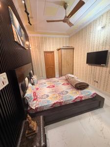 a bedroom with a bed and a flat screen tv at Meraki Homes in Karnal
